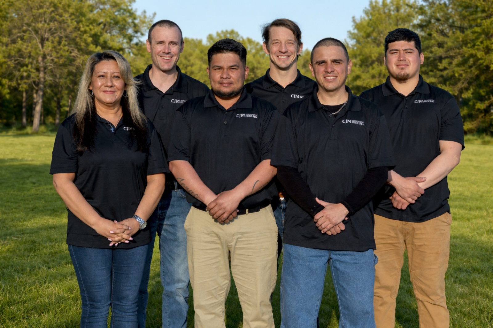 The CJM Roofing team standing together in branded CJM Roofing shirts